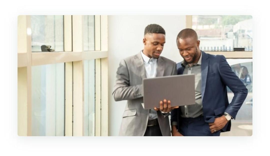 two men holding laptop